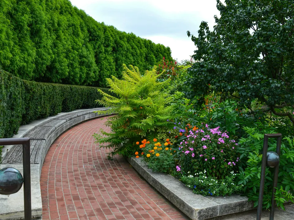 A brick garden path lined with fresh flower beds